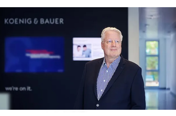 Koenig & Bauer restructuring overview showing transition to Paper & Packaging Sheetfed Systems and Special & New Technologies divisions, focusing on folding cartons, corrugated packaging, security printing, and advanced industrial printing technologies