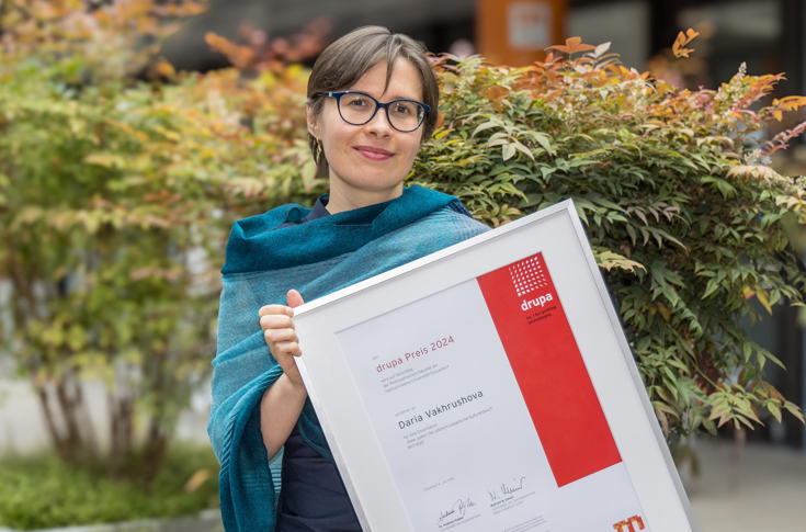 Drupa Prize 2024 award ceremony at Drupa in Düsseldorf featuring representatives from Messe Düsseldorf and Koenig & Bauer presenting the €6,000 prize to PhD winner Daria Vakhrushova for her research on Yiddish-Soviet cultural design