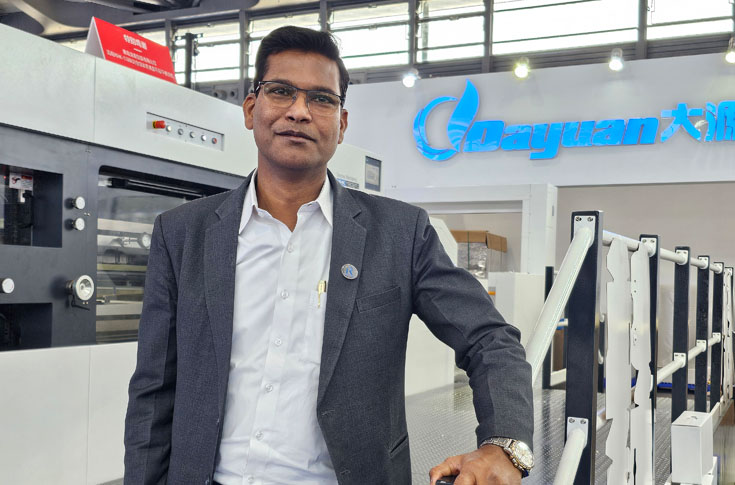 Robus India booth at China Print 2025 showcasing live demonstrations of YCIA inline Braille system, YC-1200 folder gluer, Dayuan die-cutting and hot foil machines, and XinXing film lamination equipment for advanced packaging production