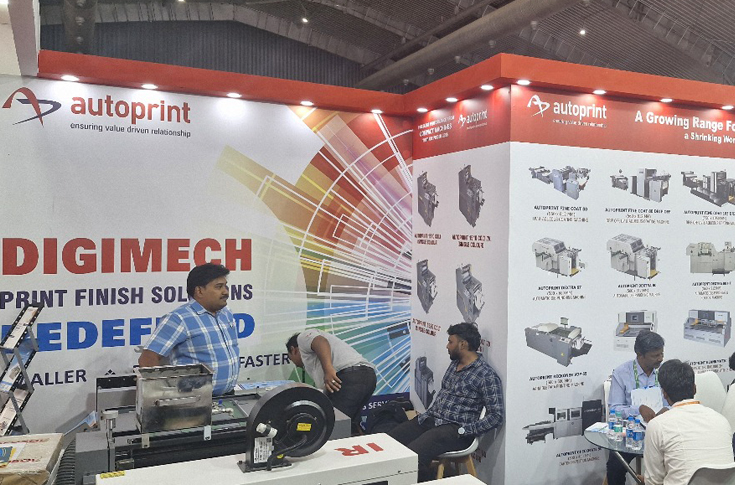Autoprint team showcasing Digimech digital finishing systems including perfect binding, die cutting, creasing, laminating, and hydraulic cutting machines at Bharat Print Expo 2025