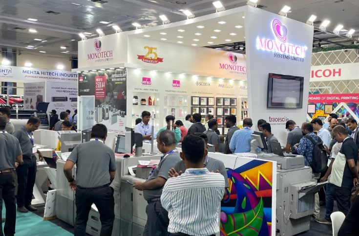 Ricoh Pro C7500 digital production press demonstrating high-quality printing with specialty toners like gold, silver, neon, and white at a print technology exhibition