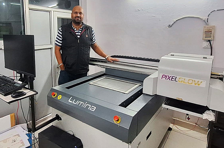 Rockfit Printers production facility showcasing PixelGlow Lumina UV embellishment machine creating high-end graphic prints with precision UV effects, highlighting advanced print finishing technology and premium output quality