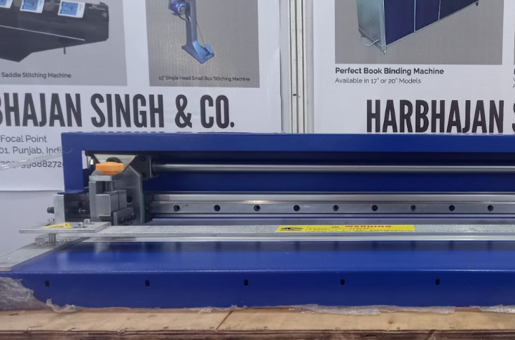 Compact industrial grooving machine weighing 18.6 kg with 700 mm maximum grooving width and 50 cycles per minute speed, shown alongside book stitching, punching, drilling, and binding machines used in print finishing
