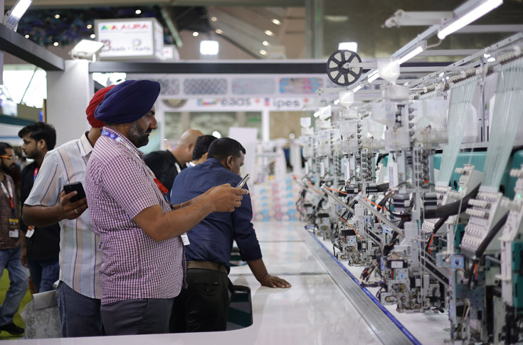 Overview of Gartex Texprocess India exhibition featuring textile manufacturing machinery, denim production value chains, fabrics, trims, accessories, and digital and screen printing solutions displayed at Yashobhoomi Expo Centre, New Delhi, with crowded exhibitor booths and industry networking activity