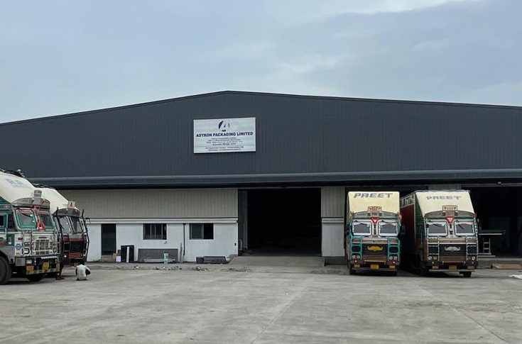 Large corrugated packaging manufacturing facility in Pune with industrial machinery and stacked cartons, supporting fresh produce export packaging and improved logistics operations
