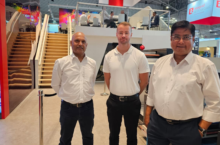 Nilpeter executives discussing flexo presses and automation at an industry expo, highlighting FA and FB line performance and India manufacturing strategy