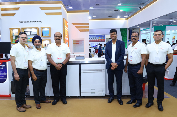 Canon imagePRESS V1000 production printer with new vacuum paper feeding system and POD Deck-F1 configuration, demonstrating high-capacity automated sheet feeding up to 10,000 sheets, supporting thick and coated media for commercial printing with improved stability and productivity
