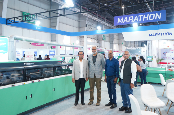 Executives from Print Plus reviewing the Bindline bookbinding system at Drupa 2024 before finalising the investment with Bindwel