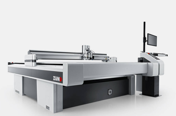 Zünd S3 and G3 digital cutting systems demonstrating automated cutting of rolled goods and board materials with robotic material handling and PortaBase 175 arm for industrial print finishing applications